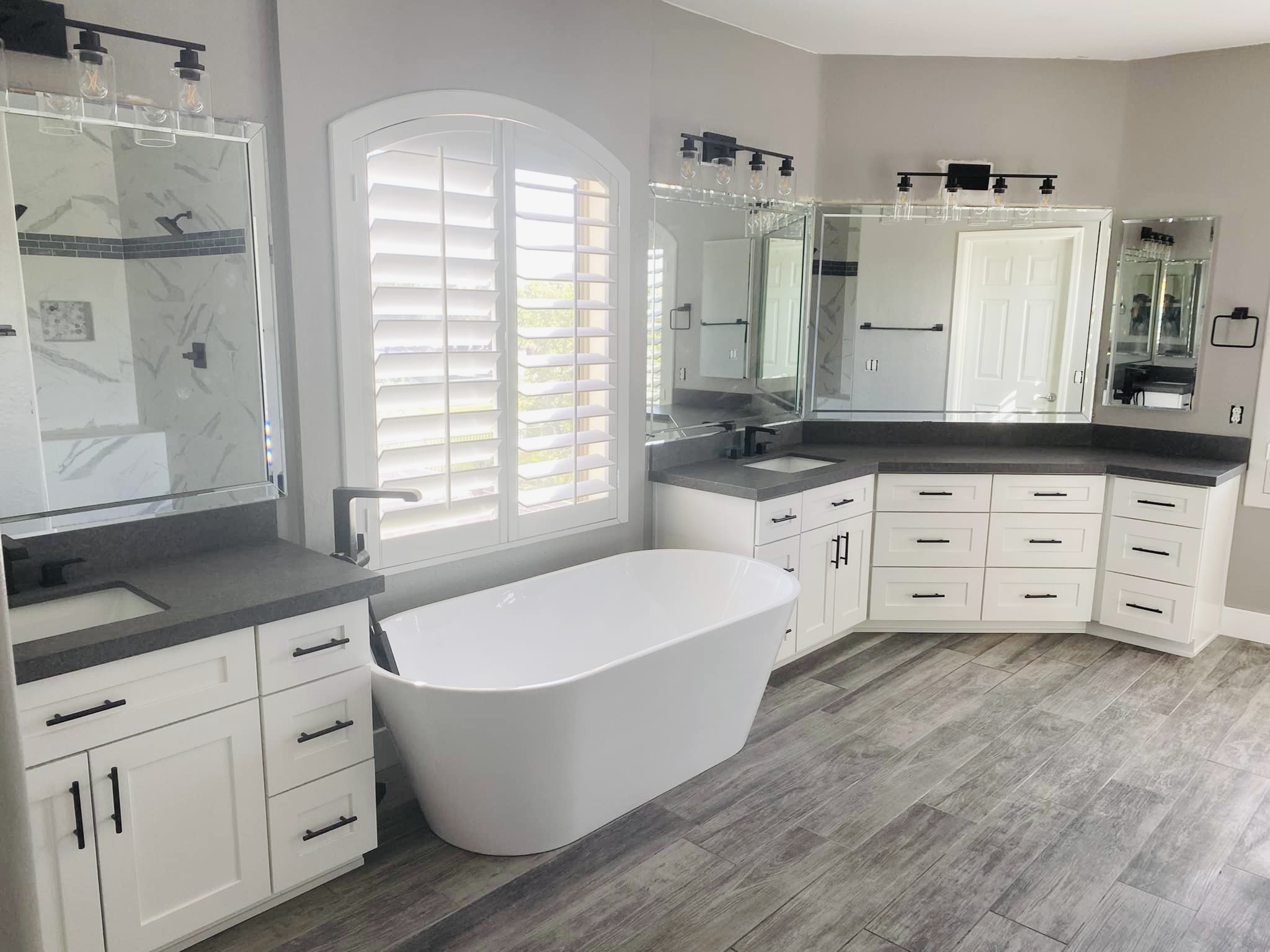 white farmhouse style master bathroom with cabinetry and bathtub